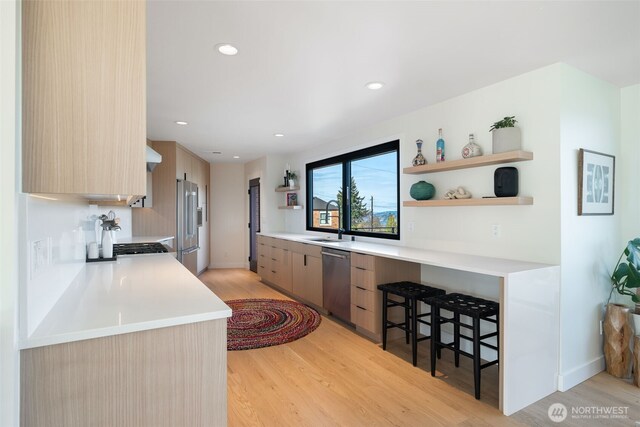 kitchen with appliances with stainless steel finishes, open shelves, modern cabinets, and a sink