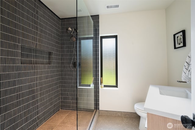 full bath with toilet, visible vents, baseboards, walk in shower, and vanity