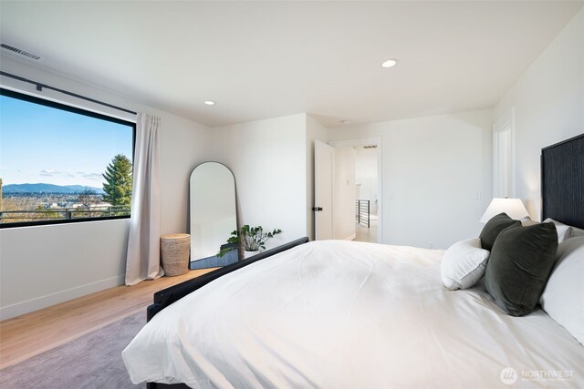 bedroom featuring recessed lighting, visible vents, wood finished floors, and a mountain view