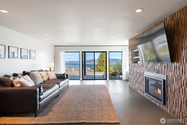living area with recessed lighting, built in features, and a glass covered fireplace