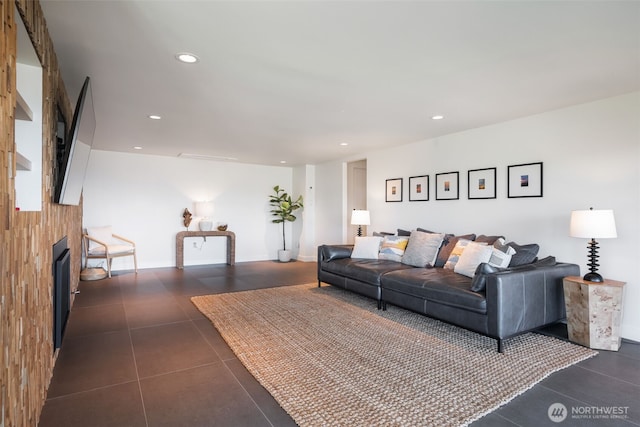 living area with recessed lighting, dark tile patterned flooring, and a fireplace