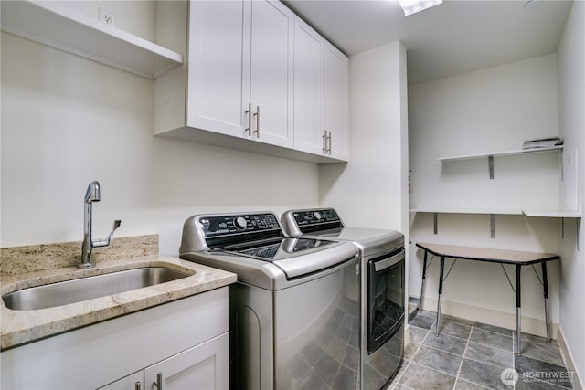 laundry area featuring washing machine and clothes dryer, a sink, and cabinet space