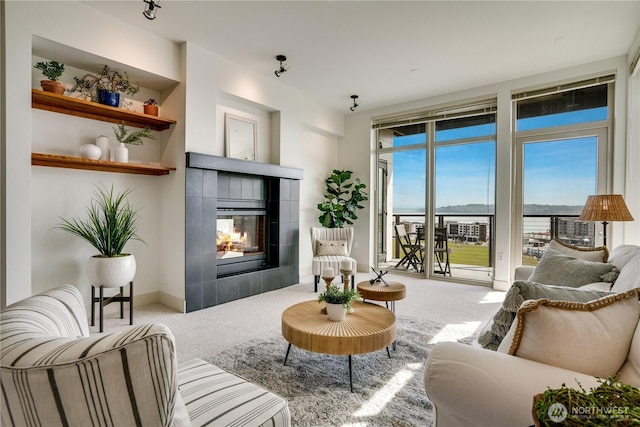 carpeted living room featuring a tile fireplace