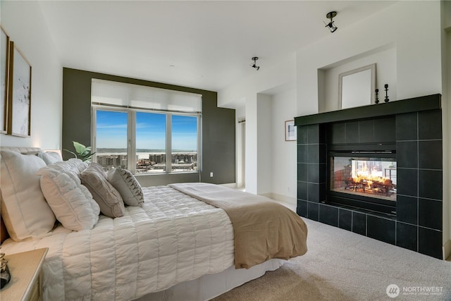 bedroom with carpet flooring and a tiled fireplace
