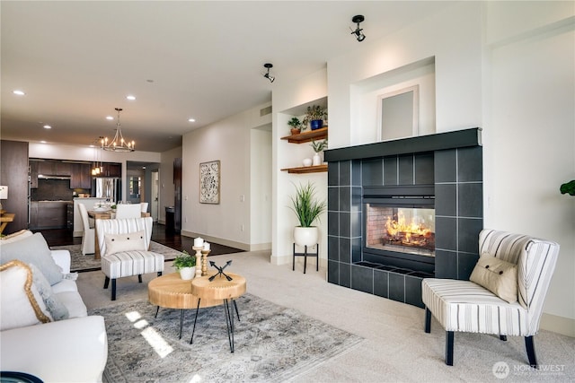 living area featuring carpet floors, visible vents, a fireplace, recessed lighting, and a chandelier