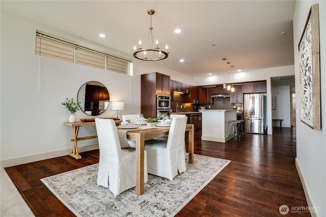 dining room featuring baseboards, recessed lighting, dark wood-style floors, and a chandelier