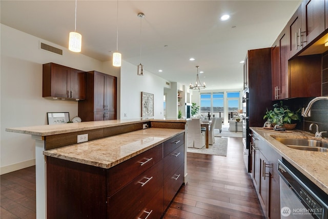 kitchen with visible vents, appliances with stainless steel finishes, a center island, a sink, and dark wood-type flooring