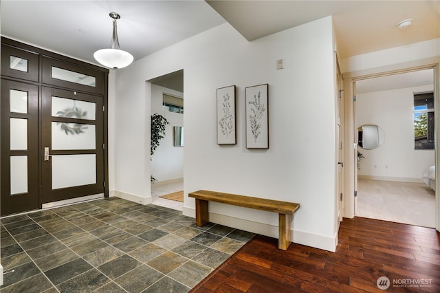 foyer entrance with dark wood-style flooring and baseboards