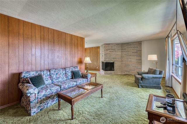 3828 Harbel Dr NE, Bremerton, WA 98310 - living room featuring wooden walls, a textured ceiling, carpet, and a fireplace