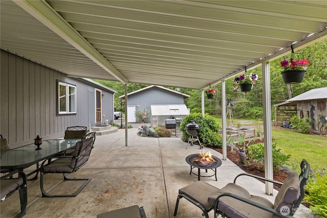 view of patio with an outdoor fire pit, an outbuilding, area for grilling, and entry steps