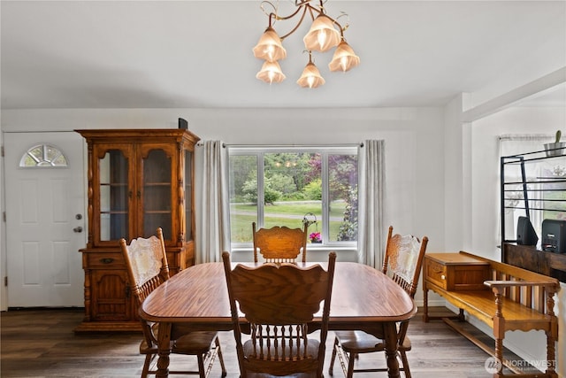 dining area with a chandelier and wood finished floors
