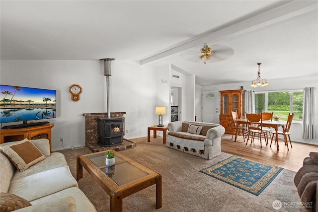 living room featuring a chandelier, a ceiling fan, and a wood stove