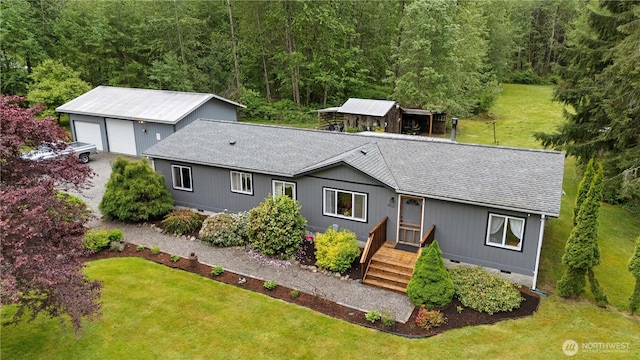 view of front of property featuring crawl space, roof with shingles, a front yard, and an outdoor structure