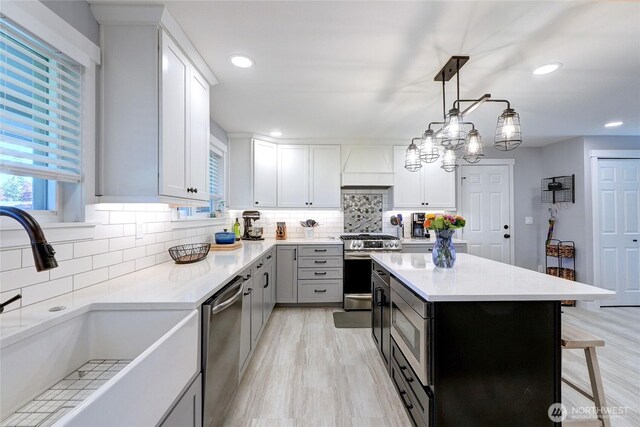 4204 Arbordale Ave W, University Place, WA 98466 - kitchen with stainless steel appliances, a sink, custom range hood, light countertops, and tasteful backsplash