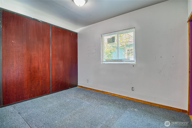 unfurnished room featuring baseboards and carpet