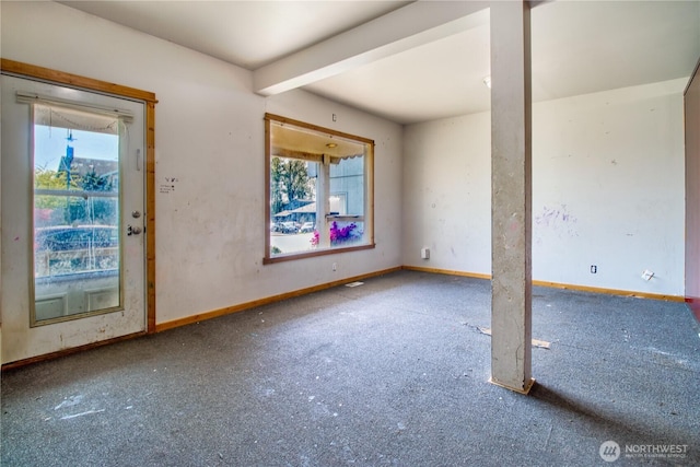 empty room with baseboards and beamed ceiling