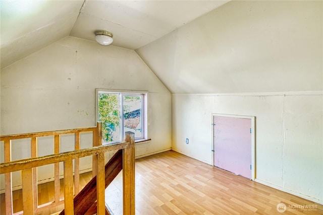 additional living space featuring lofted ceiling and wood finished floors