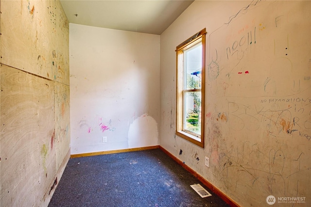 unfurnished room featuring baseboards and visible vents