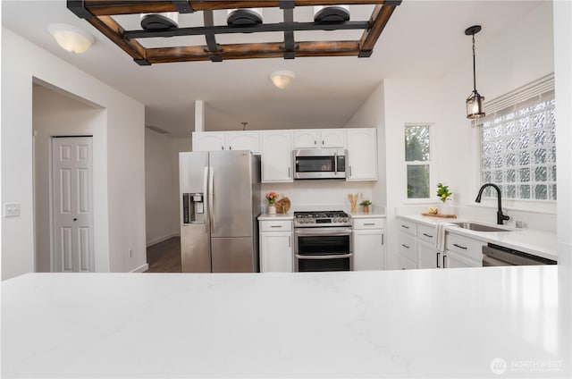 kitchen featuring light countertops, a sink, white cabinetry, and stainless steel appliances