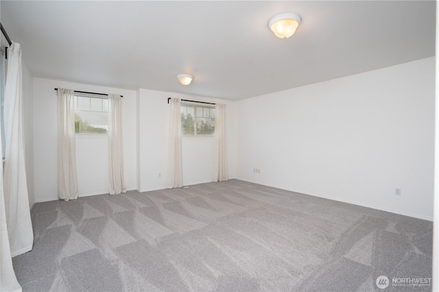 carpeted empty room with a healthy amount of sunlight