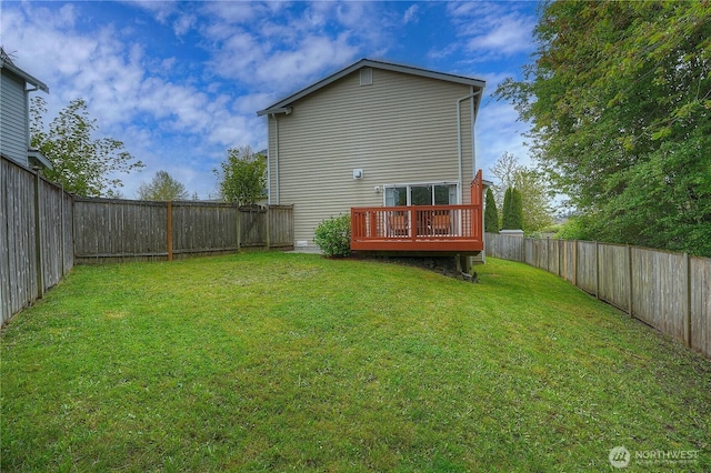 back of house with a lawn, a wooden deck, and a fenced backyard