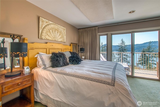 carpeted bedroom with access to outside and a mountain view