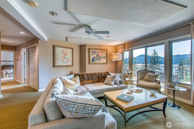 living room featuring carpet flooring, baseboards, and a mountain view