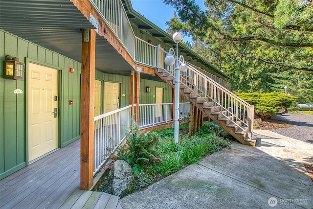 view of side of home featuring board and batten siding, stairway, and a porch
