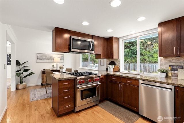 15510 NE 59th St, Redmond, WA 98052 - kitchen featuring decorative backsplash, appliances with stainless steel finishes, a sink, and light wood finished floors