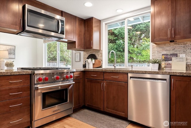 15510 NE 59th St, Redmond, WA 98052 - kitchen featuring recessed lighting, dark stone countertops, a sink, tasteful backsplash, and appliances with stainless steel finishes