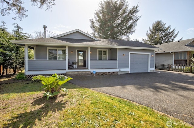 view of front of home with a porch, fence, aphalt driveway, a garage, and a front yard