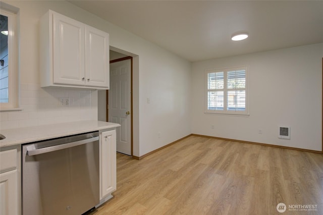 kitchen featuring white cabinets, light wood-style flooring, stainless steel dishwasher, and light countertops