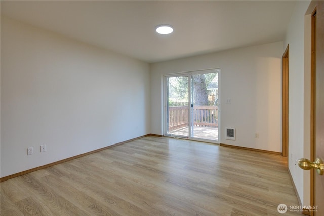 spare room featuring light wood-type flooring and baseboards