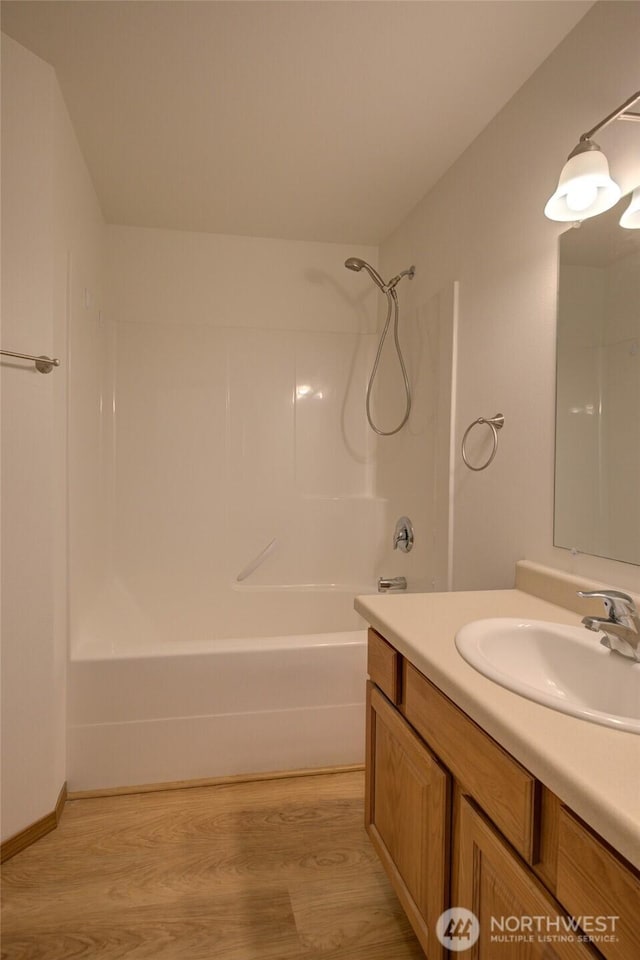 bathroom featuring shower / tub combination, wood finished floors, and vanity