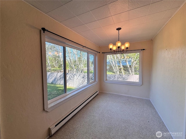 unfurnished dining area featuring a baseboard heating unit, a healthy amount of sunlight, and a textured wall