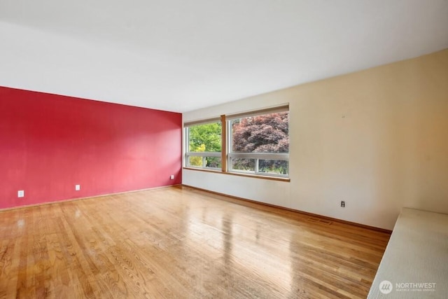 empty room with baseboards and wood finished floors