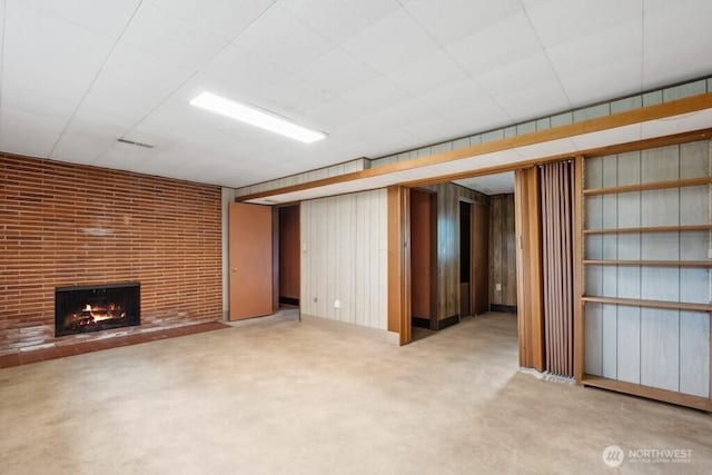 unfurnished living room with a brick fireplace and carpet flooring