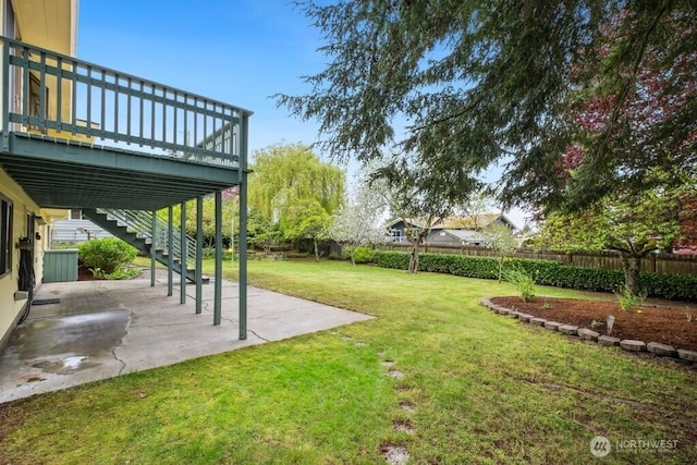 view of yard with a fenced backyard, a patio, a deck, and stairway