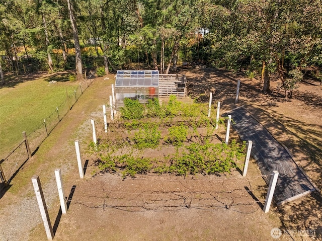 view of yard with fence, an outbuilding, an exterior structure, and a garden