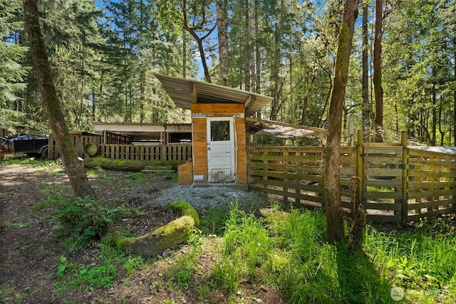 view of outdoor structure featuring a gate and fence