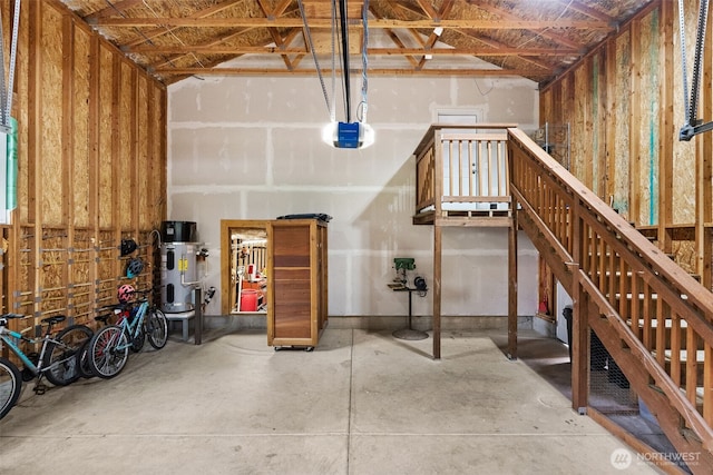 garage featuring heat pump water heater and a garage door opener