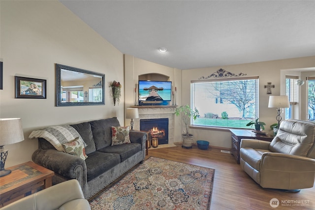 living room with a tile fireplace and wood finished floors