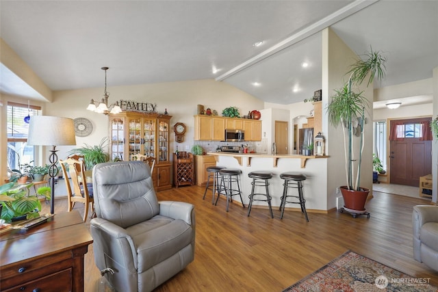 living room with light wood-style flooring, a notable chandelier, and lofted ceiling with beams