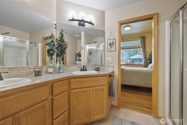 ensuite bathroom with ensuite bathroom, a sink, a shower stall, and double vanity
