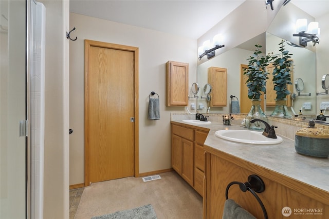 full bathroom featuring double vanity, visible vents, baseboards, and a sink