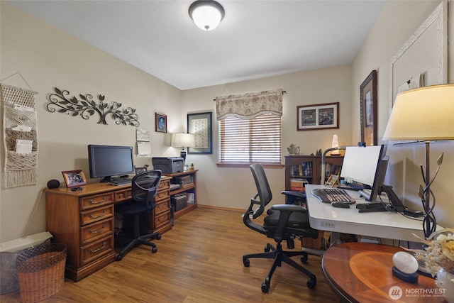 office space featuring baseboards and wood finished floors