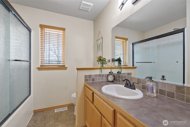 full bath featuring a wealth of natural light, toilet, and visible vents