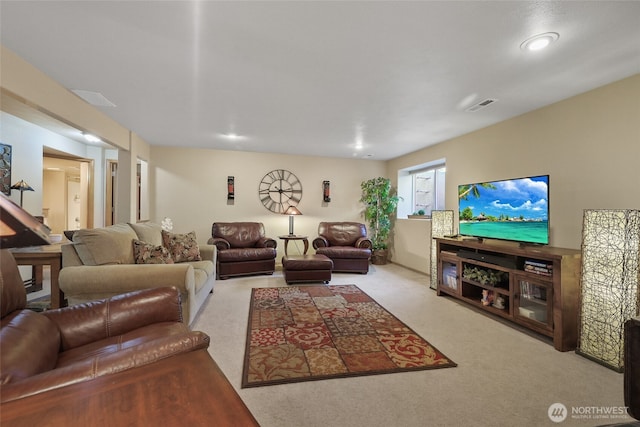 living area featuring visible vents and carpet