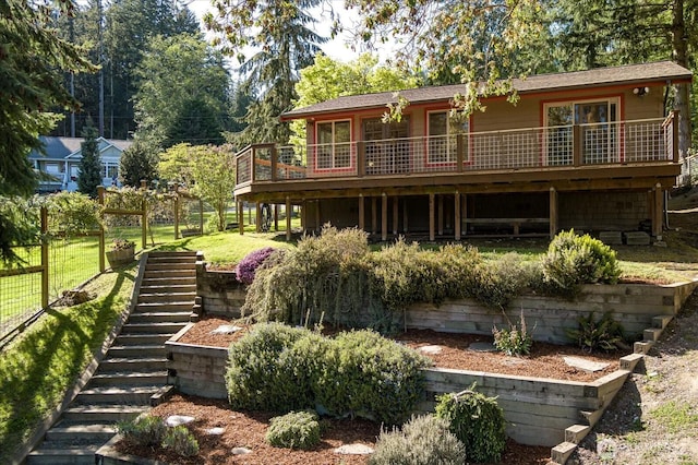back of property with stairway, a deck, a yard, and fence