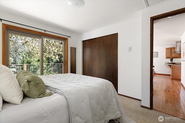 bedroom with baseboards, light carpet, and a closet